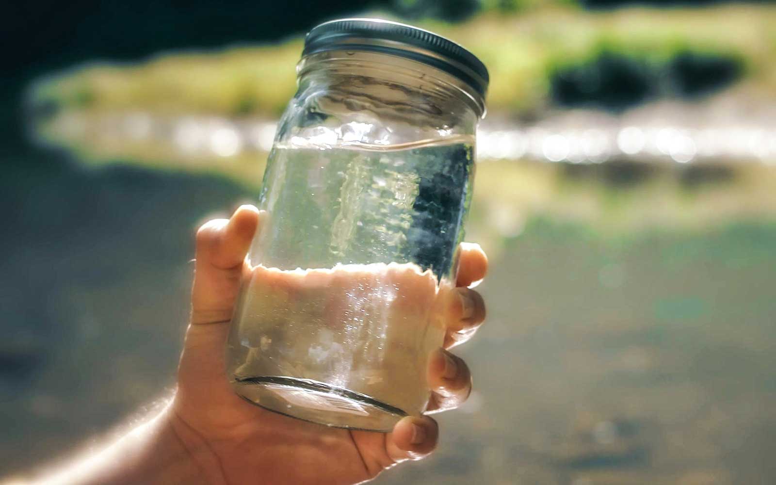 A mason jar full of white liquor distilled in Hochatown, Oklahoma from the waters of the Lower Mountain Fork River